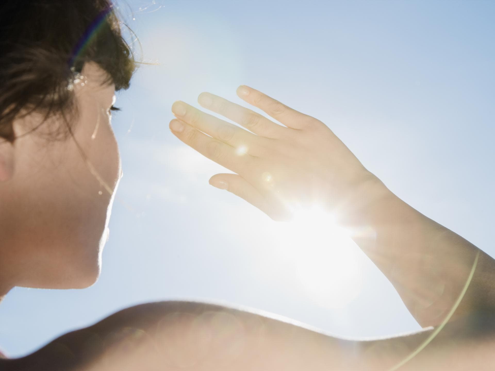 Klimaresilienz ist eine Eigenschaft, die immer wichtiger wird Eine Frau schützt sich mit der Hand vor der Sonne