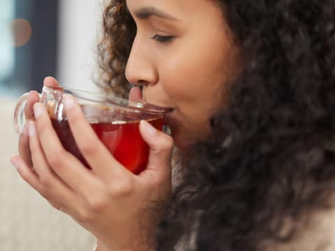 Hausmittel wie Tee helfen bei Laryngitis Frau trinkt warmen Tee