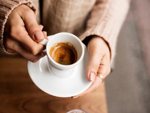 Frau hält Tasse mit Espresso in den Händen Frau hält Tasse mit Espresso in den Händen