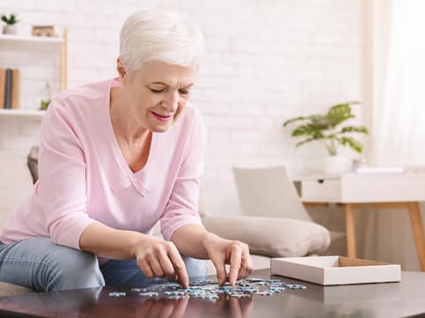 Eine Behandlung der Helicobacter pylori-Infektion kann das Risiko für Demenz senken. Frau mit Alzheimer löst Puzzle