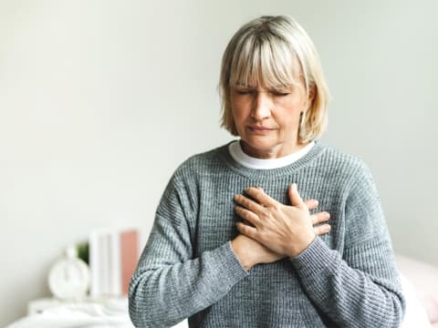 Frau fasst sich ans Herz Frau fasst sich ans Herz