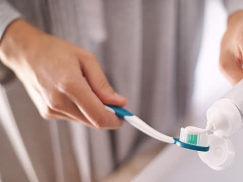 Frau trägt Zahnpasta auf ihre Zahnpasta auf Frau trägt Zahnpasta auf ihre Zahnpasta auf