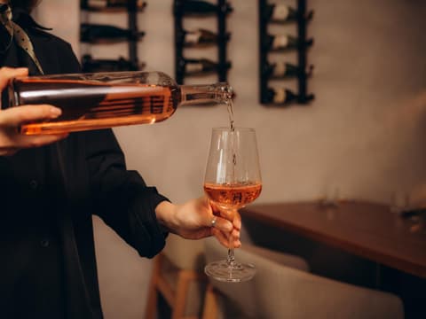 Frau schenkt sich Wein ein Frau schenkt sich Wein ein